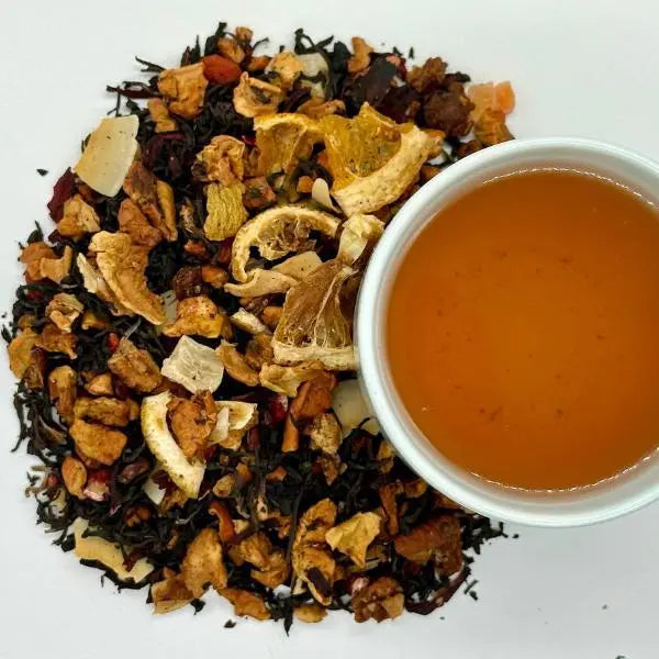 Tropical Sunrise black tea loose leaf with a brewed cup - Dragon Girl Tea